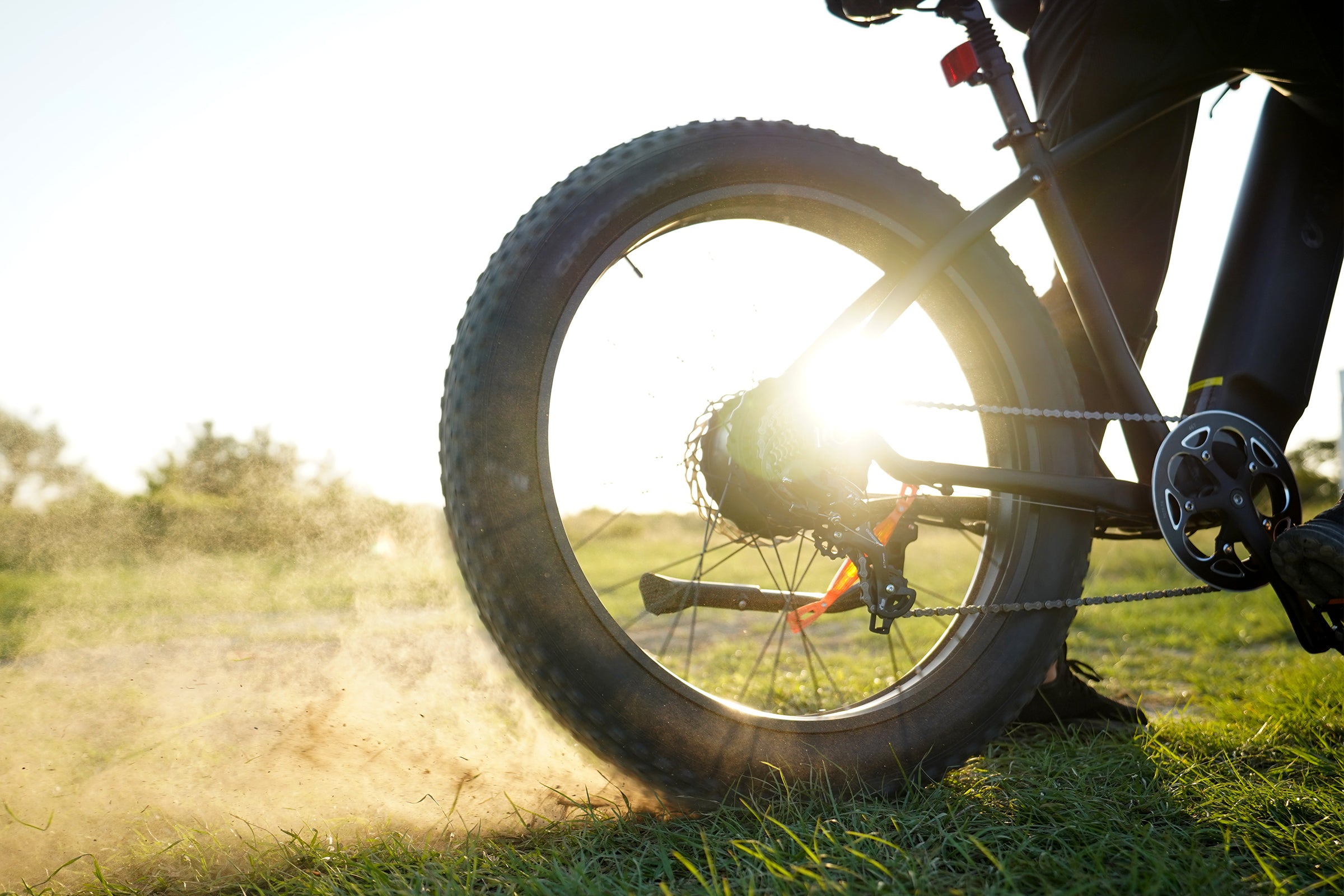 Roue arrière du vélo électrique DYU King 750 sur un chemin de terre poussiéreux Roue arrière du vélo électrique DYU King 750 sur un chemin de terre poussiéreux