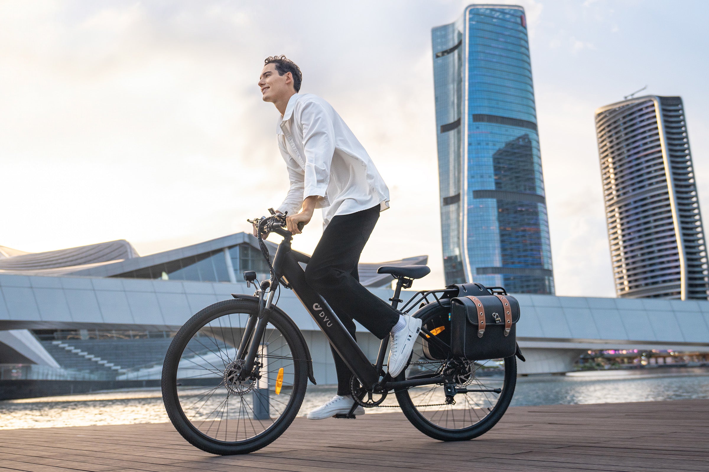 Homme utilisant le vélo électrique DYU C5 noir près de bâtiments modernes. Homme utilisant le vélo électrique DYU C5 noir près de bâtiments modernes.