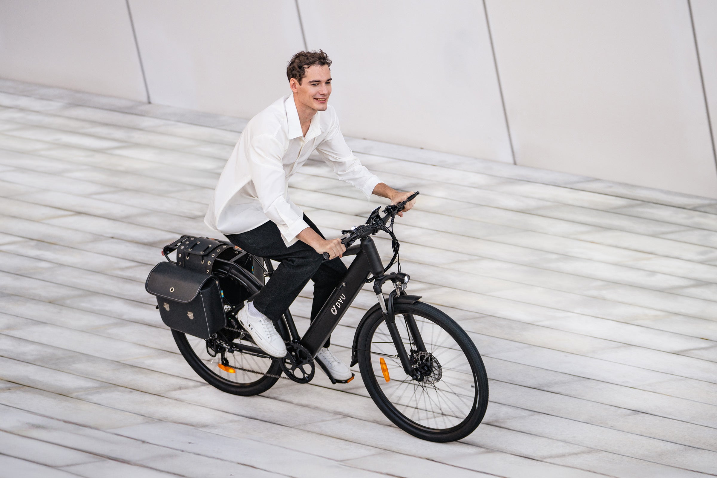 Homme souriant sur vélo électrique DYU C5 noir, parfait pour la ville. Homme souriant sur vélo électrique DYU C5 noir, parfait pour la ville.