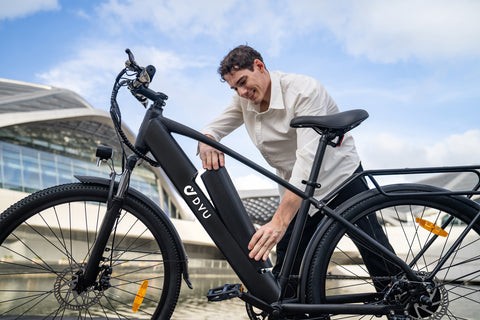 Homme retirant la batterie du vélo électrique DYU C5 noir pour trajets urbains. Homme retirant la batterie du vélo électrique DYU C5 noir pour trajets urbains.
